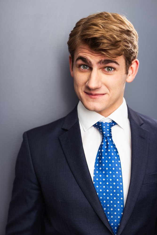 Standa Vecera studio headshot in suit and tie, playful expression